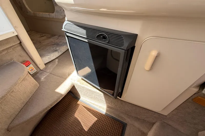 Slide: The Image of Interior of a 1996 Sea Ray 250 Sundancer boat featuring a compact refrigerator. - 29