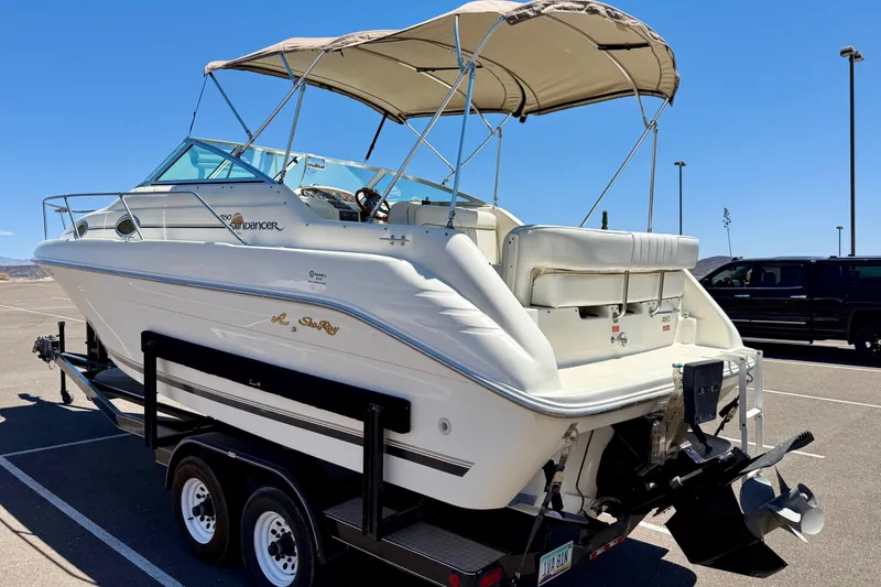 Slide: The Image of 1996 Sea Ray 250 Sundancer boat on trailer under clear blue sky. - 3