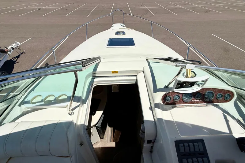 Slide: The Image of 1996 Sea Ray 250 Sundancer boat interior with dashboard and open cabin view. - 32