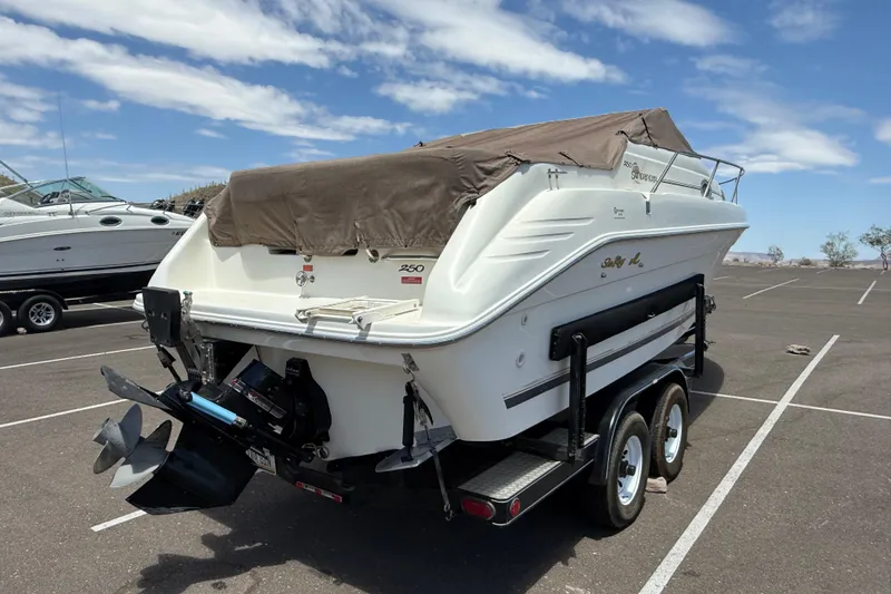 Slide: The Image of 1996 Sea Ray 250 Sundancer boat on trailer, parked in sunny lot. - 34