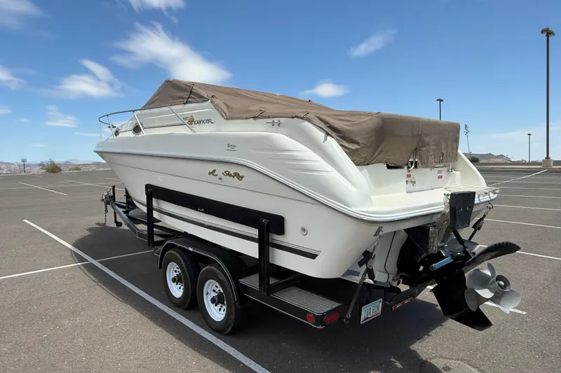 Slide: The Image of 1996 Sea Ray 250 Sundancer boat on trailer in parking lot under blue sky. - 35