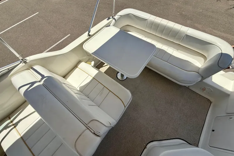 Slide: The Image of 1996 Sea Ray 250 Sundancer interior with white seating and table setup. - 8