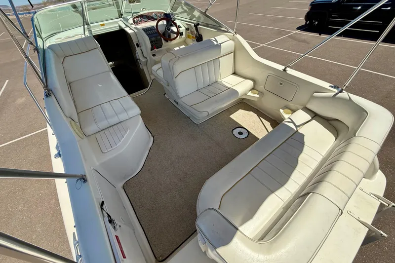 Slide: The Image of 1996 Sea Ray 250 Sundancer boat interior with white seating and steering wheel. - 9
