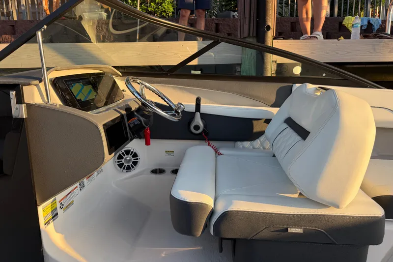 Slide: The Image of 2024 Regal LX2 boat interior with steering wheel and seating in sunlight. - 16