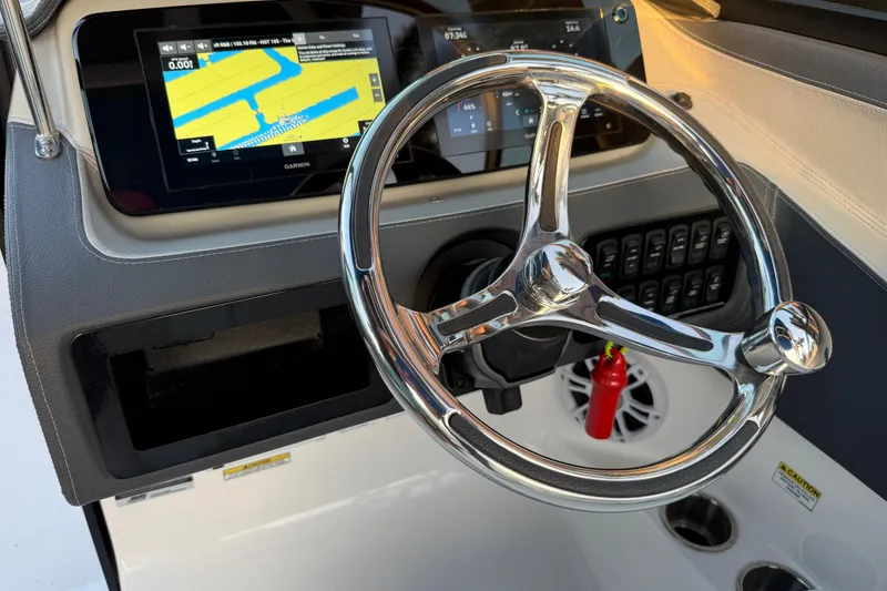 Slide: The Image of 2024 Regal LX2 boat dashboard with chrome steering wheel and navigation display. - 18