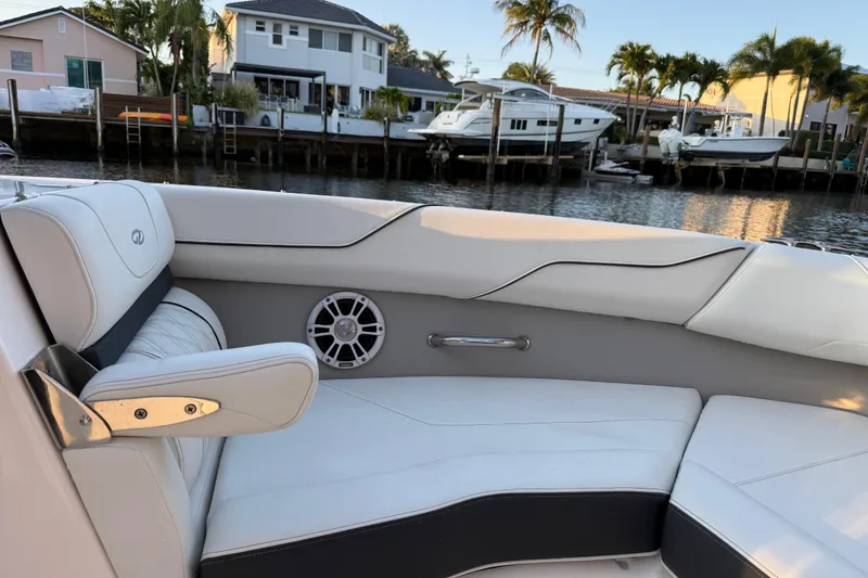 Slide: The Image of 2024 Regal LX2 boat interior with white seating, speaker, and waterfront view. - 22