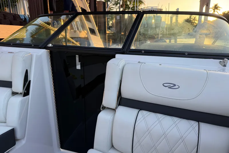 Slide: The Image of 2024 Regal LX2 boat interior with white leather seats and windshield at sunset. - 23