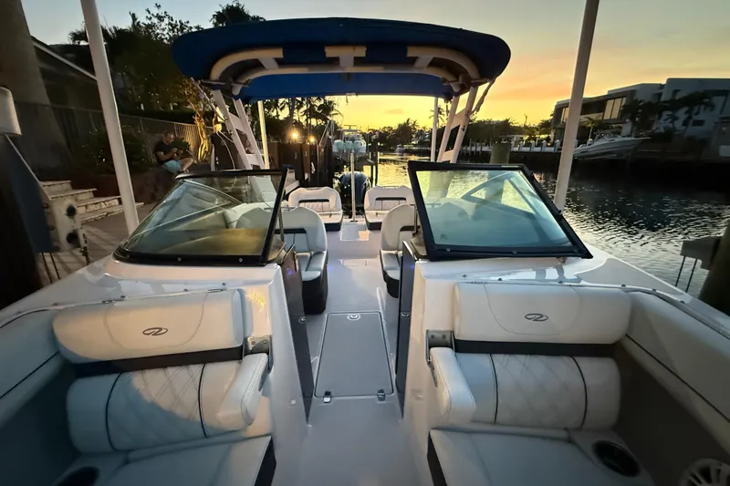 Slide: The Image of 2024 Regal LX2 boat interior at sunset, featuring luxurious seating and sleek design. - 26