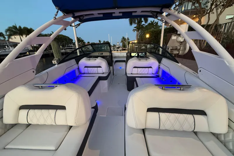 Slide: The Image of 2024 Regal LX2 boat interior with luxurious white seating and ambient blue lighting. - 28