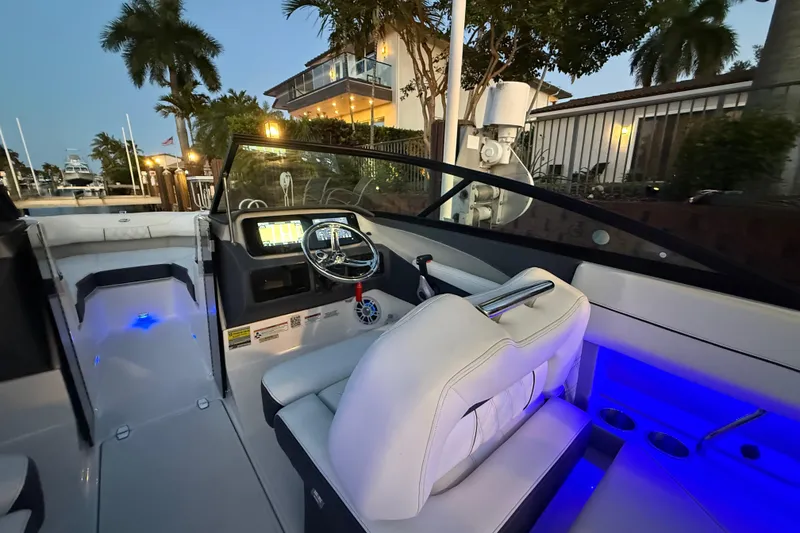 Slide: The Image of 2024 Regal LX2 boat interior with illuminated dashboard and seating, docked near a waterfront home. - 29