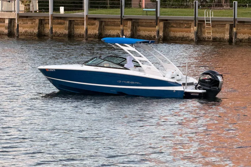 Slide: The Image of 2024 Regal LX2 boat on water, blue hull, sleek design, outboard motor. - 3