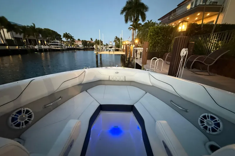 Slide: The Image of 2024 Regal LX2 boat interior at dusk, docked by a waterfront with palm trees. - 30