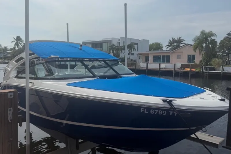 Slide: The Image of 2024 Regal LX2 boat docked, featuring blue covers and sleek design in a waterfront setting. - 33