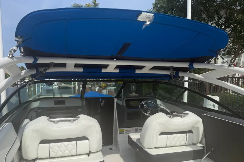Slide: The Image of 2024 Regal LX2 boat interior with blue canopy and white seating. - 34