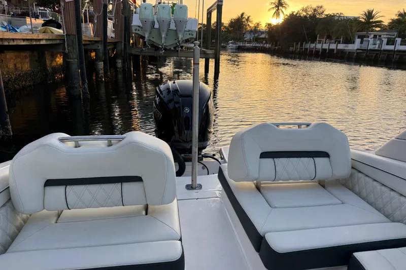 Slide: The Image of 2024 Regal LX2 boat interior with white seating, docked at sunset. - 7