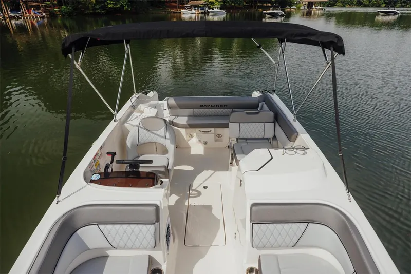 Slide: The Image of Manufacturer Provided Image: 2025 Bayliner D22I boat interior with seating, canopy, and lake view. - 5