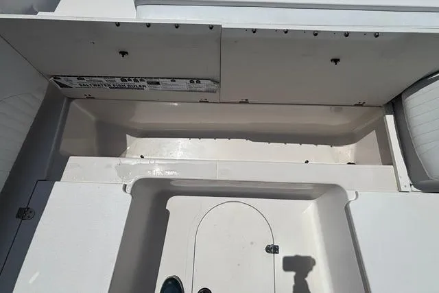 Slide: The Image of 2011 Starcraft Star Step 229 CC OB boat interior, featuring storage compartments and clean white surfaces. - 10