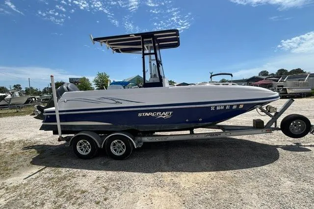 Slide: The Image of 2011 Starcraft Star Step 229 CC OB boat on trailer, parked outdoors under clear sky. - 3