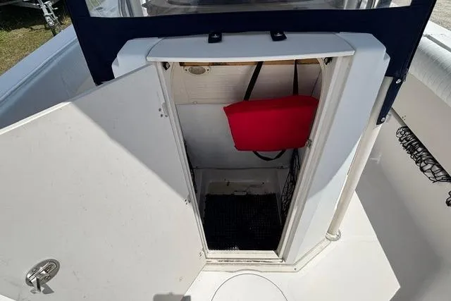Slide: The Image of 2011 Starcraft Star Step 229 CC OB boat storage compartment with open door and red life jacket. - 8