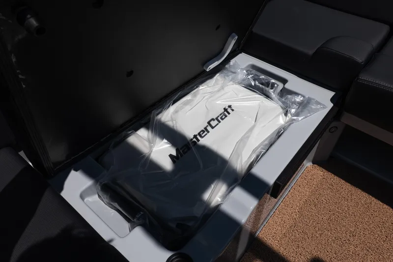 Slide: The Image of 2026 MasterCraft NXT24 boat storage compartment with branded cover. - 15
