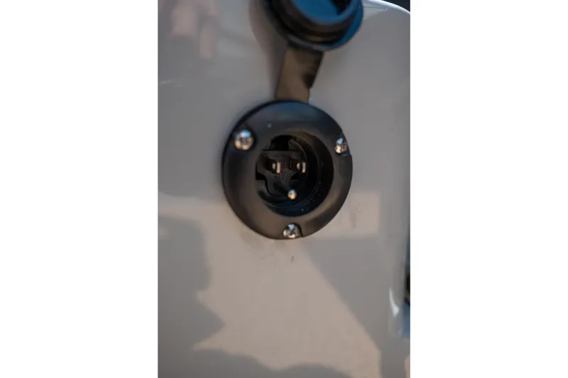 Slide: The Image of Close-up of a 2026 MasterCraft NXT24 boat plug socket on a gray surface. - 29