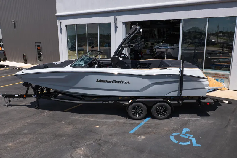 Slide: The Image of 2026 MasterCraft NXT24 boat on trailer outside dealership. - 3