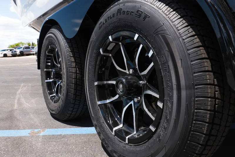 Slide: The Image of Close-up of 2026 MasterCraft NXT24 trailer wheels with sleek black rims. - 8