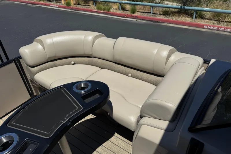 Slide: The Image of 2023 Avalon Catalina VRBW boat interior with beige seating and a black table. - 13