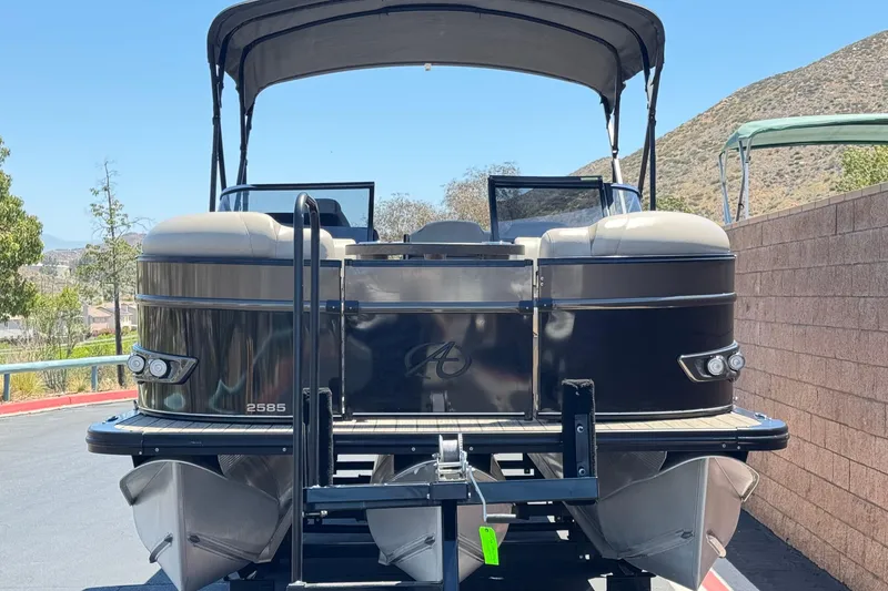 Slide: The Image of 2023 Avalon Catalina VRBW pontoon boat with canopy, parked outdoors on a sunny day. - 2