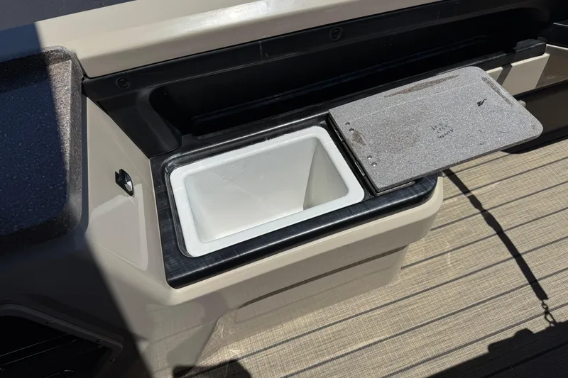 Slide: The Image of Open storage compartment on 2023 Avalon Catalina VRBW boat, featuring a white interior and hinged lid. - 26