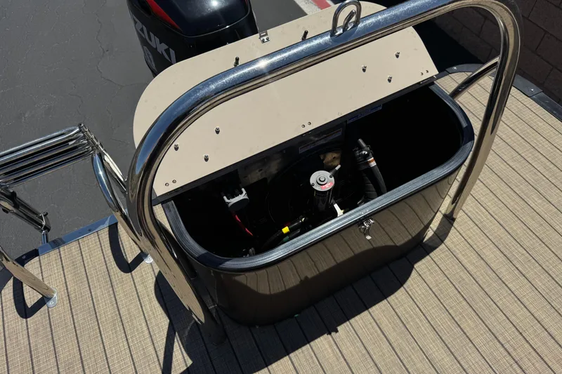 Slide: The Image of 2023 Avalon Catalina VRBW boat engine compartment with Suzuki motor, open hatch, and metal railing. - 29