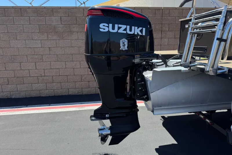 Slide: The Image of 2023 Avalon Catalina VRBW with Suzuki outboard motor, parked on pavement. - 7