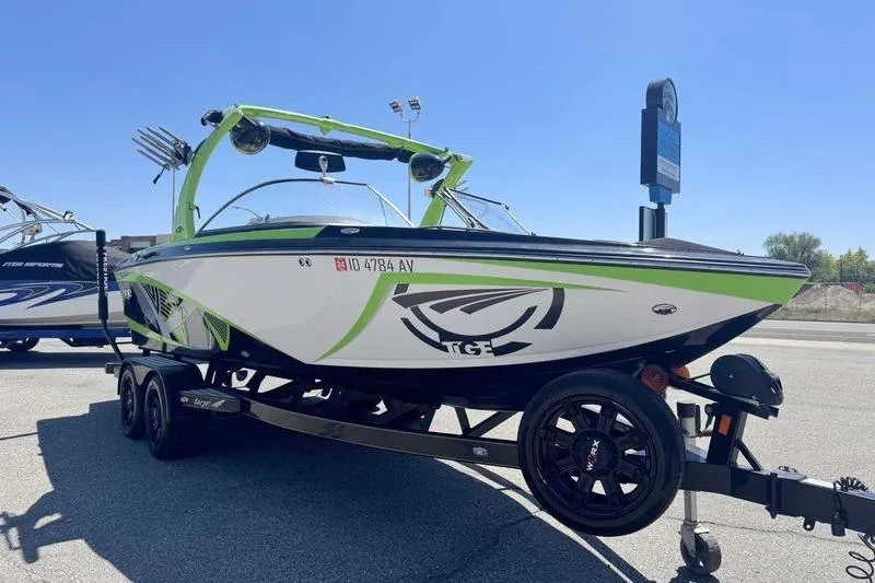Slide: The Image of 2015 Tigé Z1 boat with green accents on a trailer in a parking lot. - 10