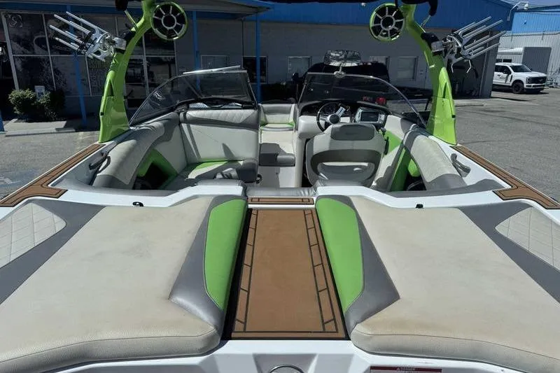 Slide: The Image of 2015 Tigé Z1 boat interior with green and white seating, open windshield, and outdoor setting. - 12