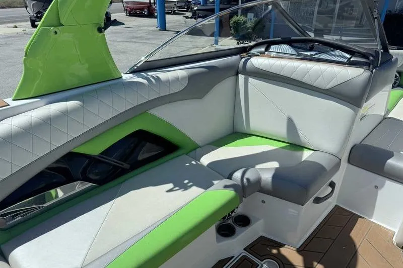 Slide: The Image of 2015 Tigé Z1 boat interior with green and white seating, steering wheel, and dashboard. - 14