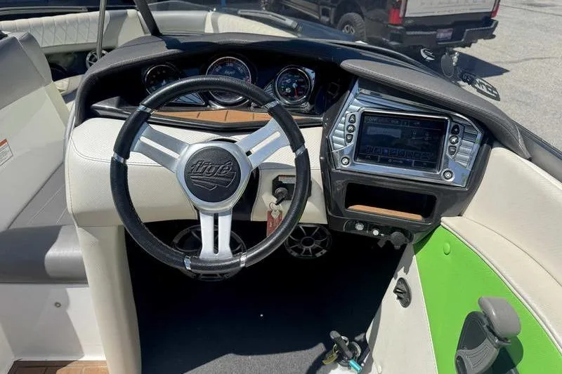 Slide: The Image of 2015 Tigé Z1 boat dashboard with steering wheel and control panel. - 2