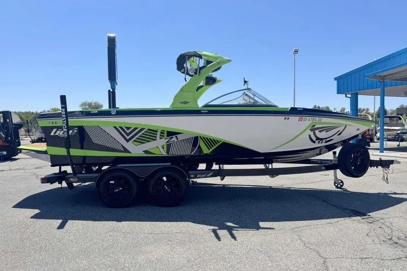 Slide: The Image of 2015 Tigé Z1 boat with vibrant green and black design on a trailer. - 3