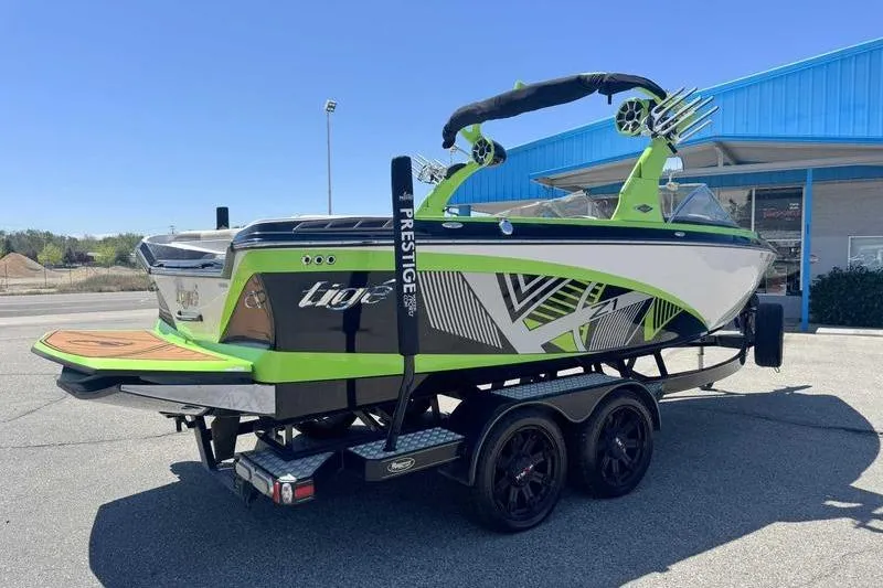 Slide: The Image of 2015 Tigé Z1 boat on trailer, vibrant green and black design, parked outdoors. - 7