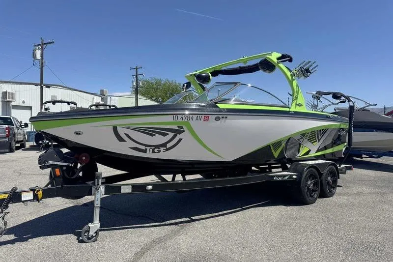 Slide: The Image of 2015 Tigé Z1 boat on trailer, vibrant green accents, parked outdoors. - 9