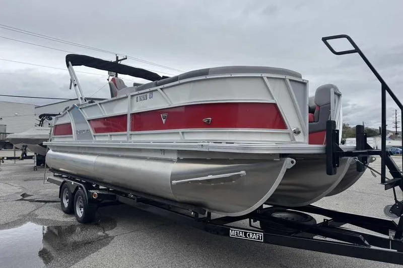 Slide: The Image of 2022 Trifecta SS 23RF pontoon boat on trailer, featuring red and silver design. - 13