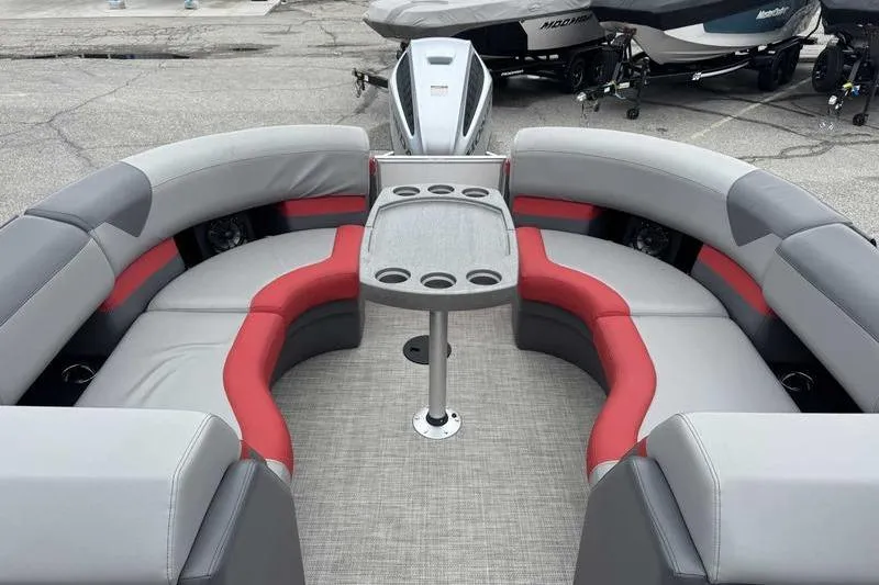 Slide: The Image of 2022 Trifecta SS 23RF pontoon boat interior with gray and red seating, table, and cup holders. - 16