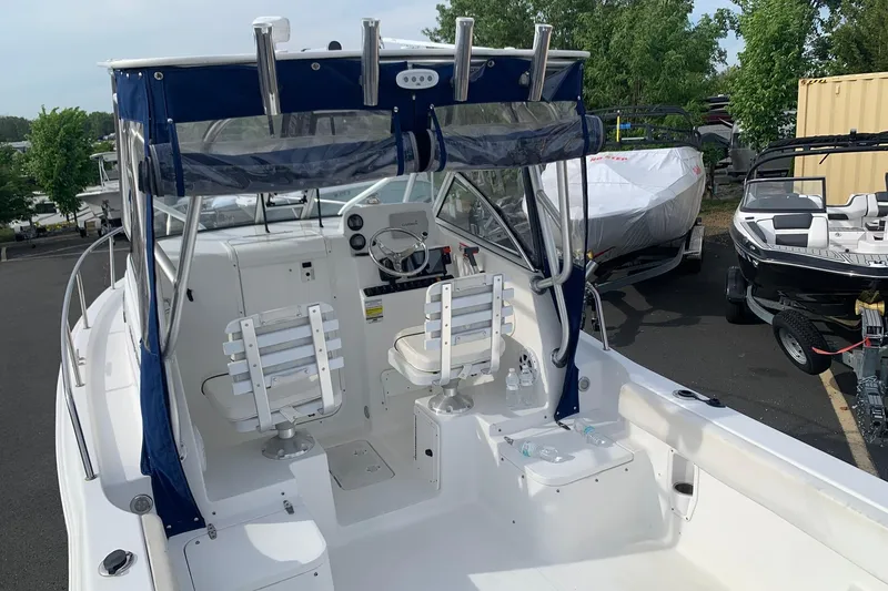 Slide: The Image of 2014 Sea Hunt Victory 225 boat interior with seating and steering wheel, parked outdoors. - 4