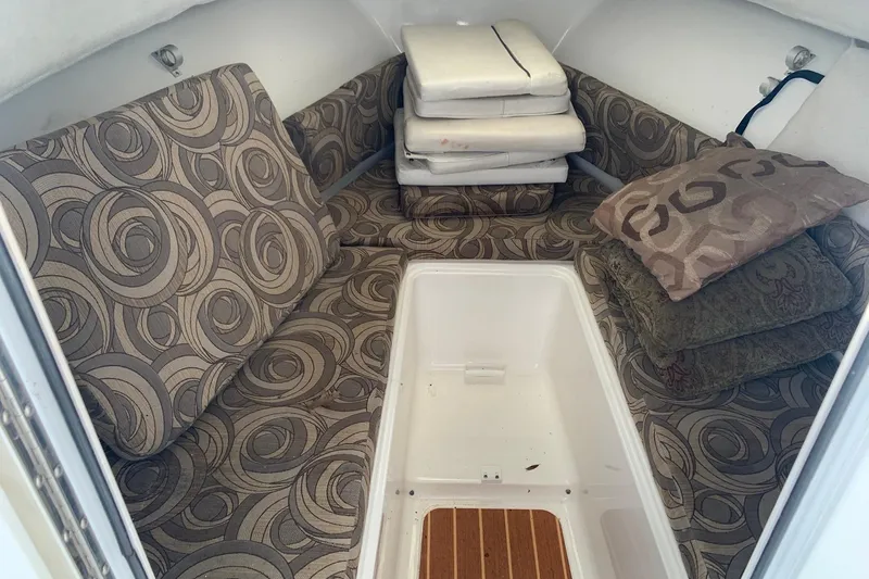 Slide: The Image of 2014 Sea Hunt Victory 225 cabin interior with patterned cushions and storage space. - 8