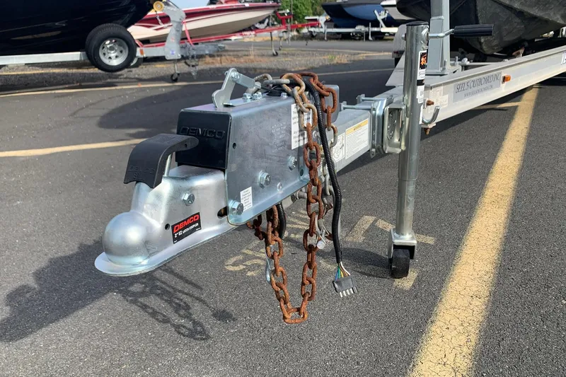 Slide: The Image of Trailer hitch of a 2014 Sea Hunt Victory 225 boat, featuring Demco coupler and safety chains. - 9