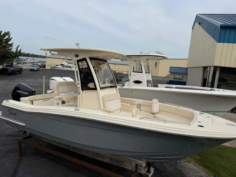 Slide: The Image of A 2027 Scout 220 XSF boat is on a trailer in a marina area. - 1