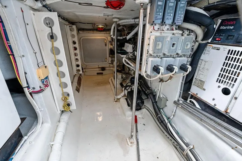 Slide: The Image of Engine room of 2006 Hatteras 68 Convertible yacht, showcasing electrical panels and wiring. - 68