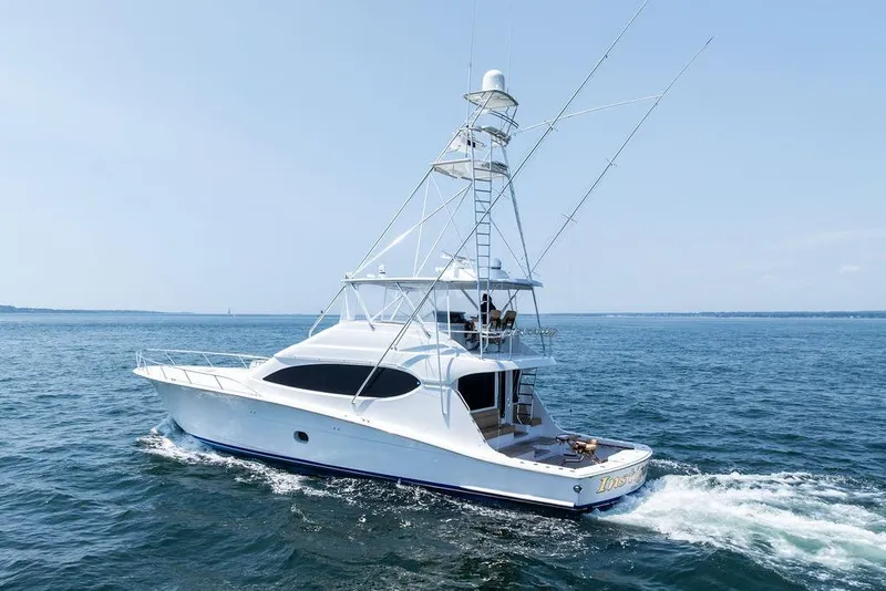 Slide: The Image of 2006 Hatteras 68 Convertible yacht cruising on open water under clear skies. - 8