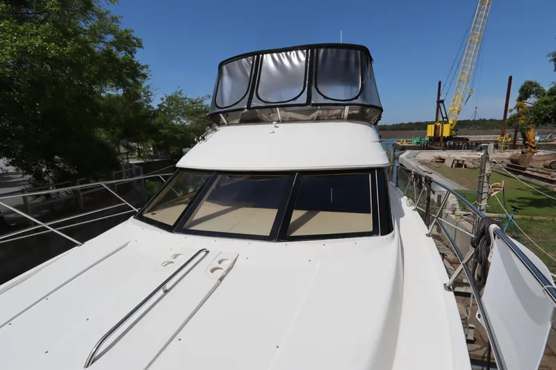 Slide: The Image of 2005 Meridian 459 Motoryacht docked near construction site, clear sky background. - 6