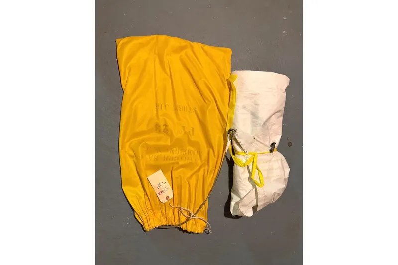 Slide: The Image of Yellow and white PAC 23 parachute from 1976, neatly packed with label attached. - 11