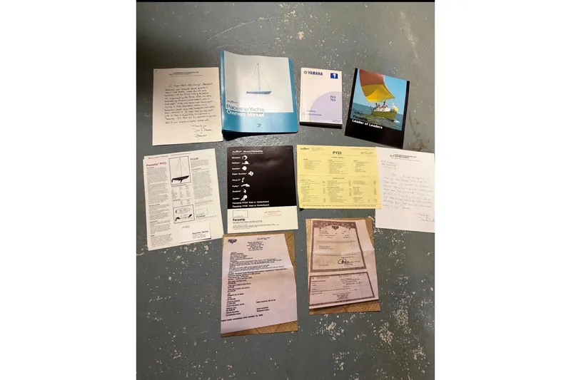 Slide: The Image of Assorted 1976 PAC 23 yacht manuals and documents displayed on a textured surface. - 3